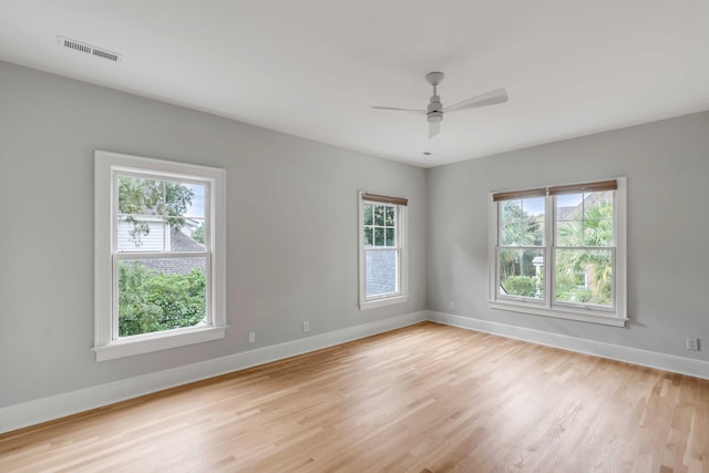 empty room with light hardwood / wood-style floors, plenty of natural light, and ceiling fan