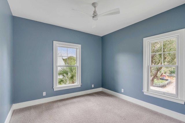 spare room featuring a wealth of natural light, carpet flooring, and ceiling fan