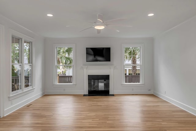 unfurnished living room with ceiling fan, a healthy amount of sunlight, and light wood-type flooring