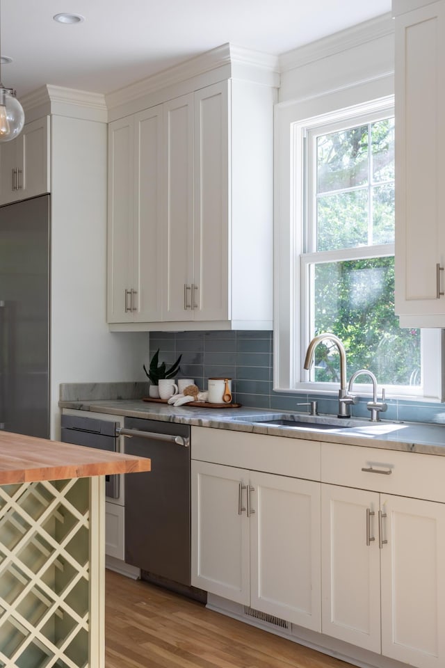 517 Royall Ave, Mount Pleasant, SC 29464 - kitchen with stainless steel dishwasher, plenty of natural light, a sink, tasteful backsplash, and crown molding