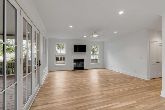 unfurnished living room with ceiling fan, ornamental molding, light hardwood / wood-style flooring, and a wealth of natural light