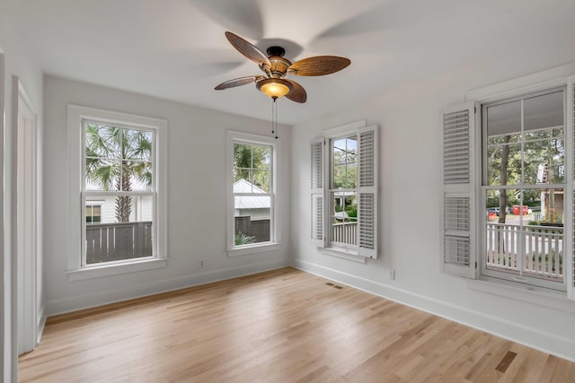 empty room with ceiling fan and light hardwood / wood-style flooring