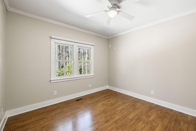 spare room with dark wood finished floors, baseboards, visible vents, and ornamental molding