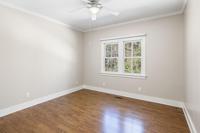 spare room with baseboards, visible vents, dark wood-style flooring, and ornamental molding