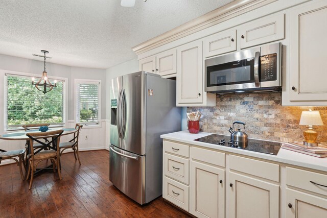 kitchen featuring appliances with stainless steel finishes, a textured ceiling, decorative backsplash, light countertops, and dark wood-style flooring