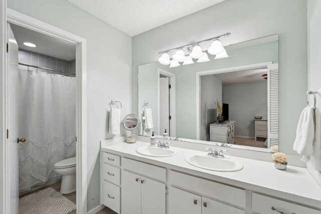 full bath with double vanity, toilet, and a shower with curtain