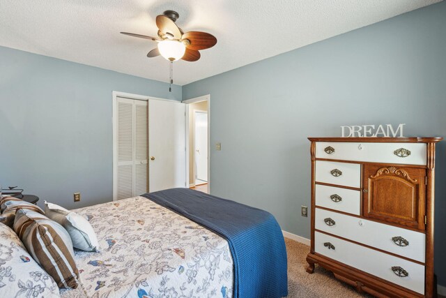 bedroom featuring light colored carpet, a closet, baseboards, and a ceiling fan