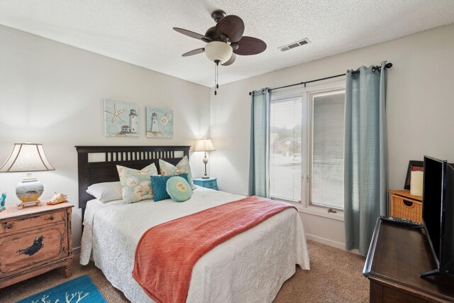 bedroom featuring carpet floors, a textured ceiling, and a ceiling fan