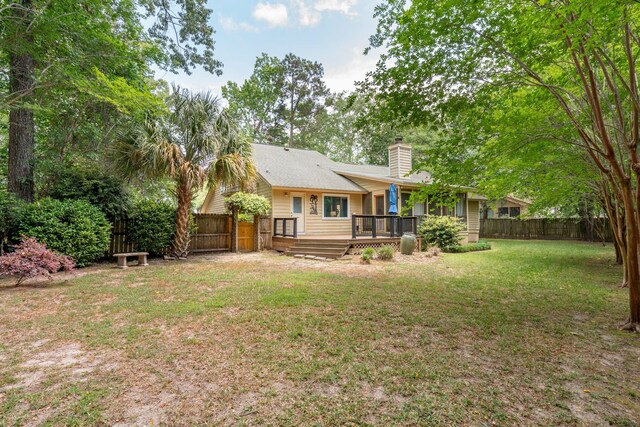 rear view of property with a deck and a chimney