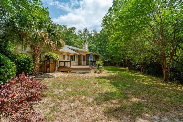 view of yard with a wooden deck and a sunroom
