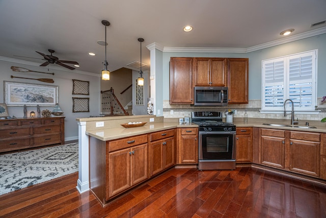 kitchen featuring sink, hanging light fixtures, stainless steel appliances, dark hardwood / wood-style floors, and kitchen peninsula