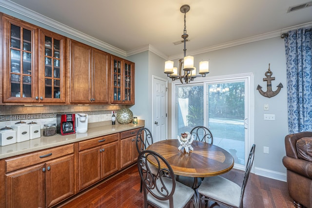 dining area with a notable chandelier, dark hardwood / wood-style floors, and ornamental molding