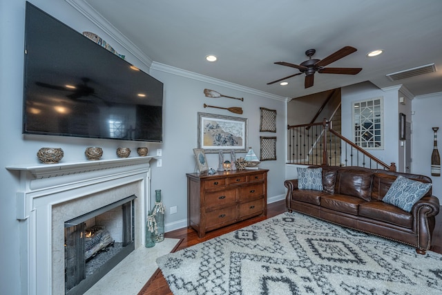 living room with wood-type flooring, ceiling fan, and ornamental molding