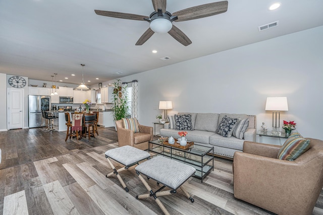 living room featuring ceiling fan and light hardwood / wood-style flooring