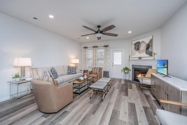 living room featuring ceiling fan and light hardwood / wood-style floors