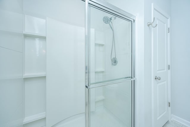 bathroom featuring a shower with shower door