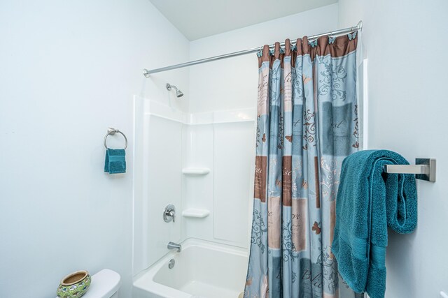 bathroom featuring shower / bath combo and toilet