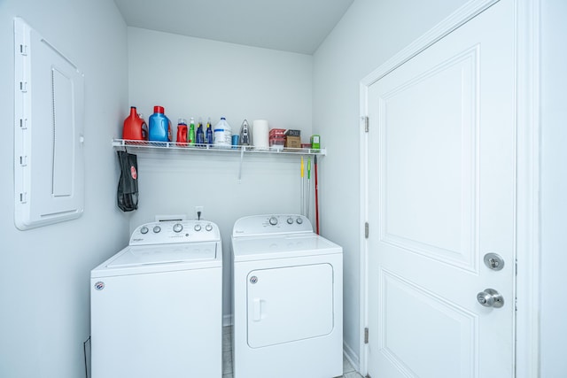 clothes washing area with washing machine and dryer and electric panel