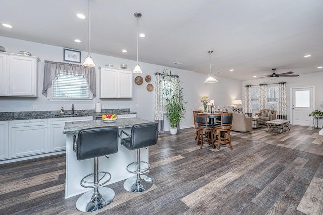 kitchen featuring white cabinetry, sink, ceiling fan, and pendant lighting