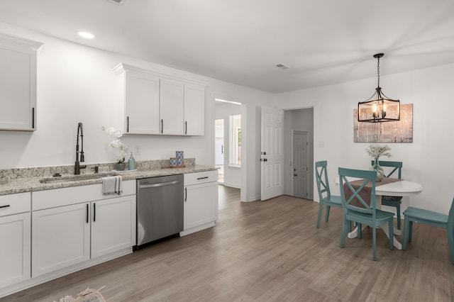 kitchen with stainless steel dishwasher, a sink, light wood finished floors, white cabinetry, and baseboards