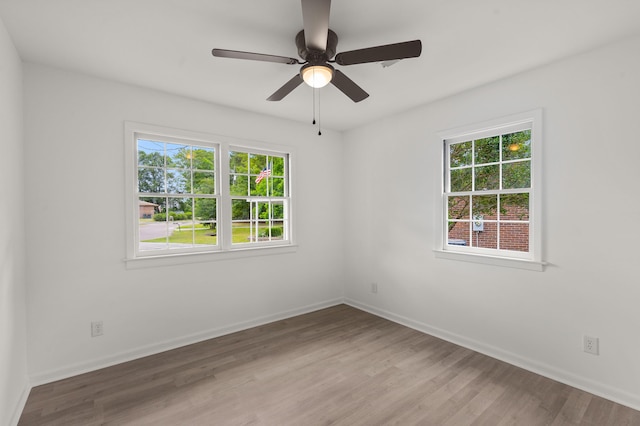spare room featuring wood finished floors, baseboards, and ceiling fan