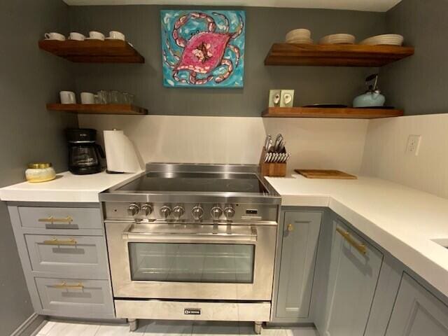 kitchen featuring open shelves, light countertops, and stainless steel stove