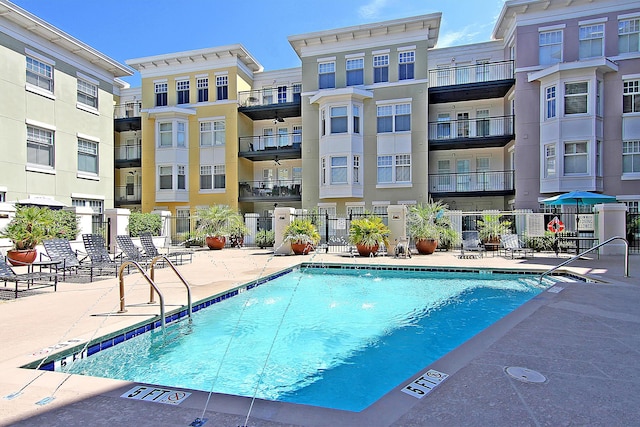 pool with a patio and fence