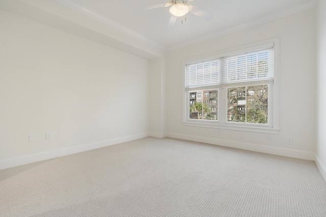 unfurnished room featuring light carpet, ceiling fan, baseboards, and ornamental molding