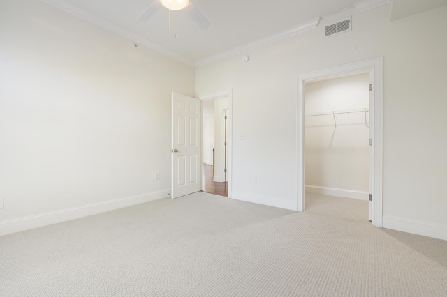 unfurnished bedroom featuring baseboards, light colored carpet, visible vents, and ornamental molding