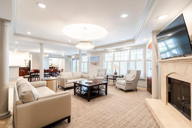 living room with a premium fireplace, decorative columns, recessed lighting, crown molding, and a raised ceiling