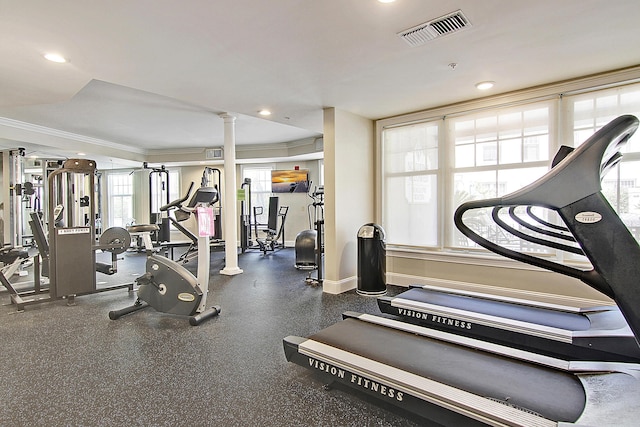 exercise room with visible vents, crown molding, baseboards, recessed lighting, and ornate columns