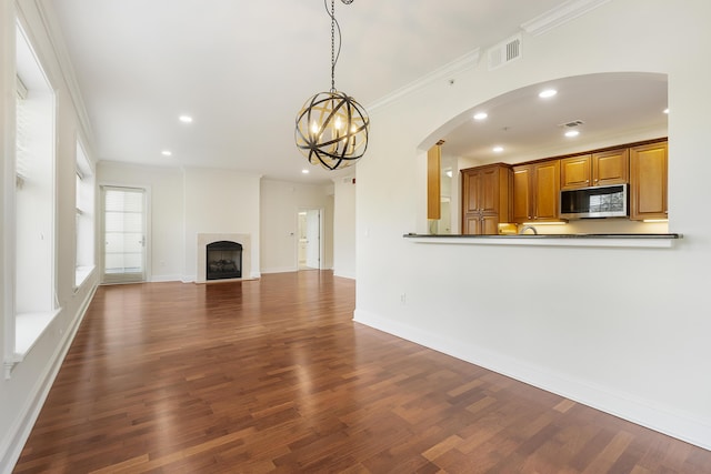 unfurnished living room featuring visible vents, recessed lighting, crown molding, dark wood-style flooring, and a tile fireplace