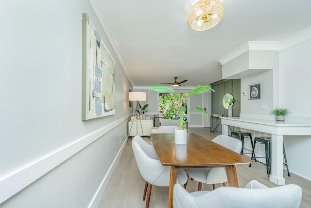 dining area featuring light wood-type flooring, ceiling fan, and ornamental molding