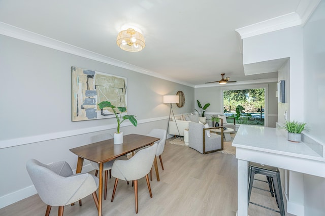 dining space with ceiling fan, ornamental molding, and light hardwood / wood-style flooring