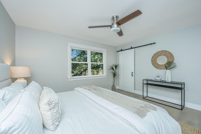 bedroom with ceiling fan and a barn door