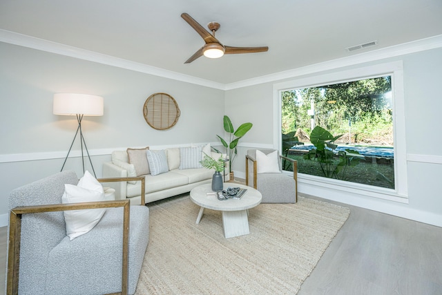 living room with ceiling fan, ornamental molding, and hardwood / wood-style flooring