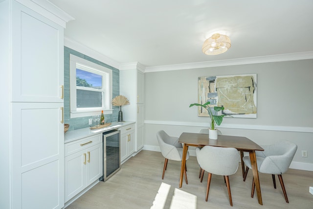 kitchen featuring white cabinetry, beverage cooler, crown molding, decorative backsplash, and light wood-type flooring