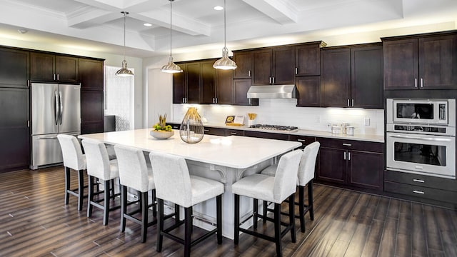 kitchen featuring decorative light fixtures, appliances with stainless steel finishes, dark wood-type flooring, and a kitchen island