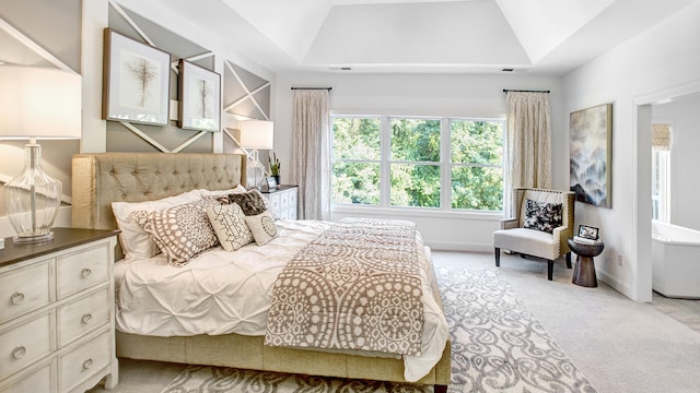 bedroom featuring a raised ceiling, lofted ceiling, and light carpet