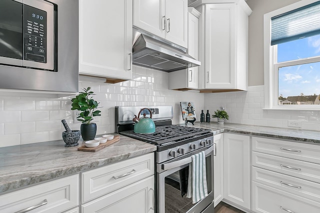 kitchen with white cabinetry, decorative backsplash, stainless steel appliances, and light stone counters