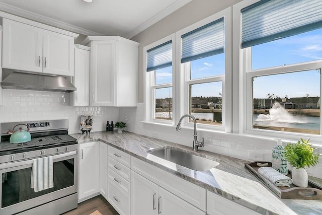 kitchen with stainless steel gas stove, sink, white cabinets, and a water view