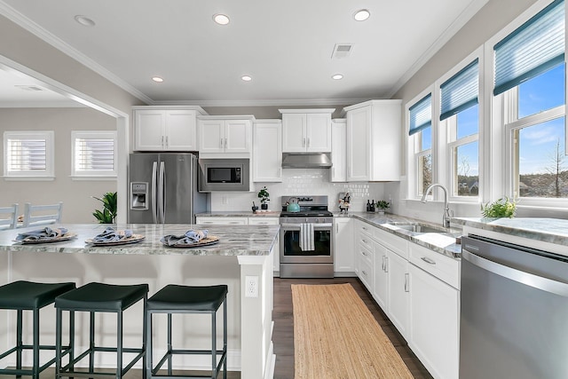 kitchen featuring sink, light stone countertops, white cabinets, and appliances with stainless steel finishes