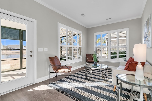 living area featuring hardwood / wood-style floors and crown molding