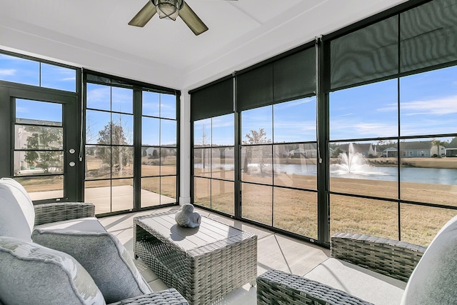 sunroom featuring ceiling fan and a water view