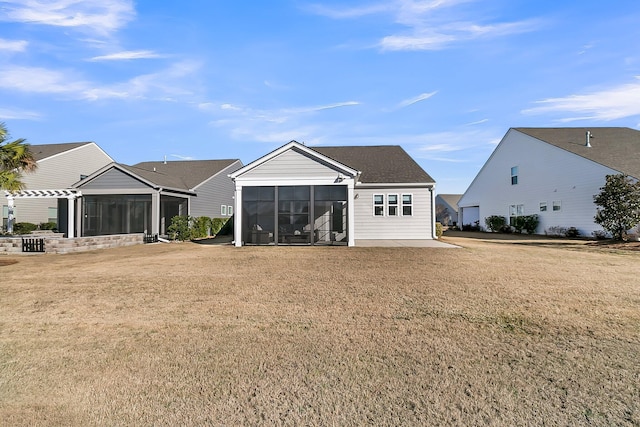 rear view of property with a sunroom, a yard, and a patio area