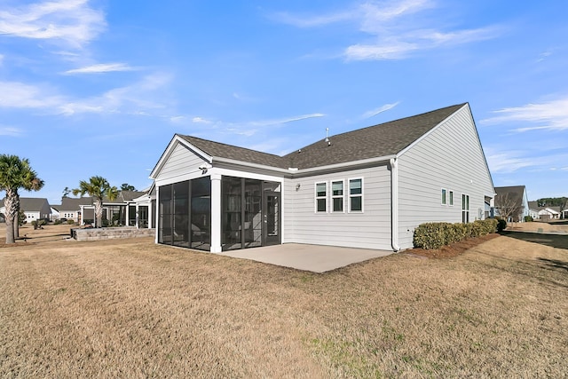 rear view of property with a patio area, a sunroom, and a lawn