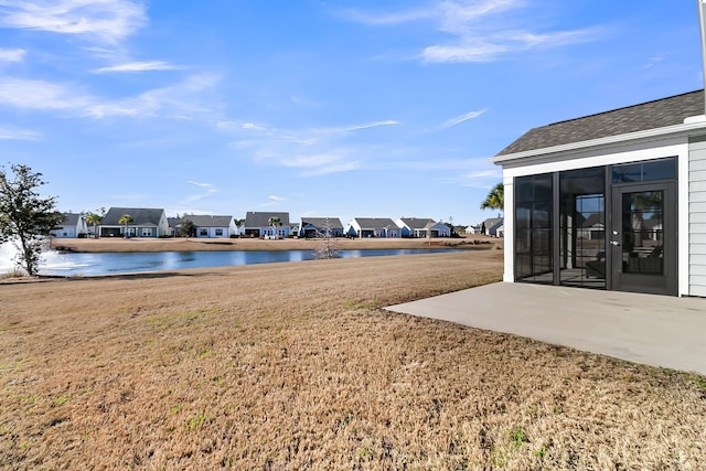 view of yard with a water view and a patio area