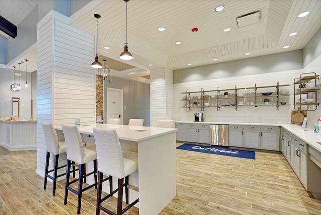 kitchen featuring gray cabinets, dishwasher, a kitchen breakfast bar, decorative light fixtures, and wooden ceiling