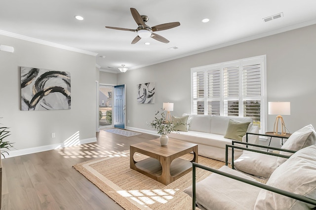 living room featuring ceiling fan, ornamental molding, and hardwood / wood-style floors