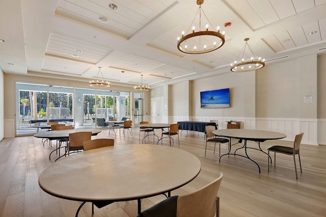 dining space with coffered ceiling, beamed ceiling, light hardwood / wood-style floors, and a chandelier